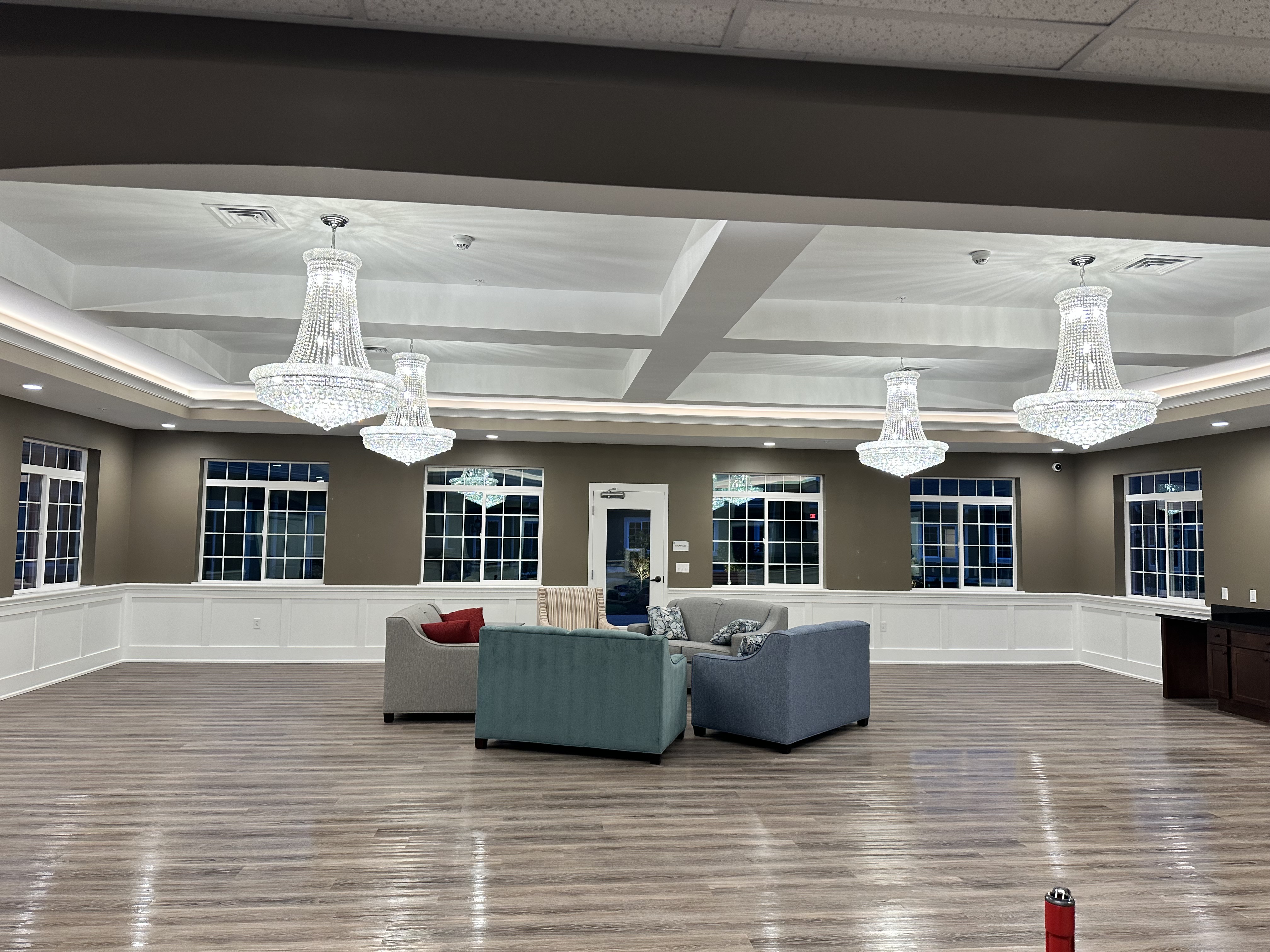 A bright, spacious event hall with chandeliers and lounge seating